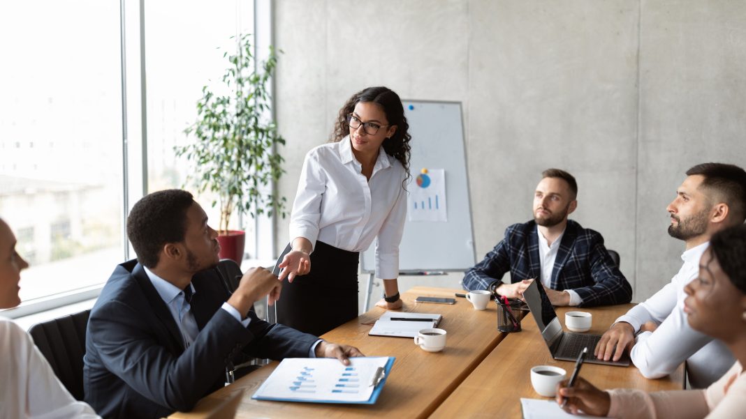 businesswoman-on-business-meeting-talking-with-colleagues-standing-in-office